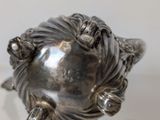 a silver sculpture of a woman ' s face on a glass table