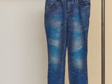 jeans hanging on a clothes rack in front of a white wall