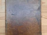 un vieux livre posé sur une table en bois, sur un parquet