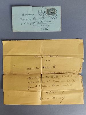 une vieille enveloppe à laquelle est joint un mot et un bout de papier sur lequel il y a quelque chose d'écrit