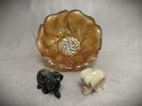 two figurines of elephants and a bowl on a table