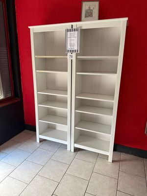 deux bibliothèques blanches dans une pièce aux murs rouges