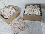trois boîtes remplies de cailloux blancs posées sur un tissu blanc