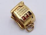 an image of a gold coin machine charm on a white surface
