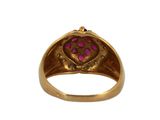 a close up of a gold ring with a pink stone in the center