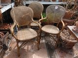 trois chaises en osier posées sur une terrasse en briques