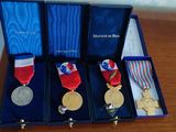 three medals are in a blue box on a wooden table