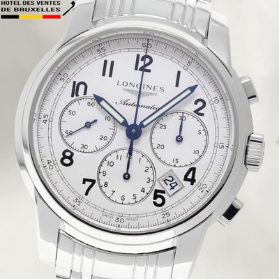 un gros plan d'une montre en acier inoxydable avec un cadran blanc