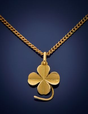 a gold four leaf clover pendant on a gold chain