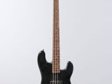 a black electric bass guitar hanging from a white wall