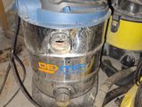 un aspirateur posé par terre à côté d'autres outils