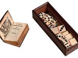 un vieux livre et un jeu de dominos dans une boîte en bois