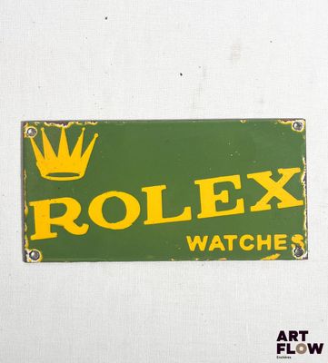 une enseigne représentant une montre Rolex verte et jaune sur un mur blanc