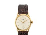 une montre-bracelet en or jaune 18 carats avec un cadran blanc