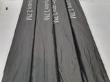 four black umbrellas are lined up on a white surface