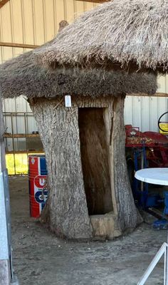 une petite cabane faite d'un tronc d'arbre et recouverte d'un toit de chaume