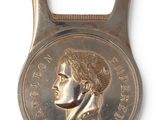 bottle opener shaped like a coin with a portrait of a woman