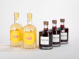 trois bouteilles de gin sont alignées sur une surface blanche