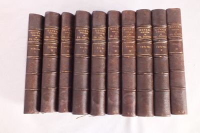 six vieux livres sont alignés sur une surface blanche
