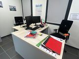 une image représentant un bureau avec un bureau et deux écrans