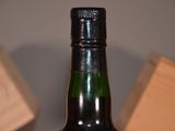a bottle of whiskey sitting on a table with a wooden block in the background