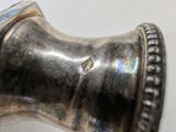 a close up of a silver vase with a diamond on it