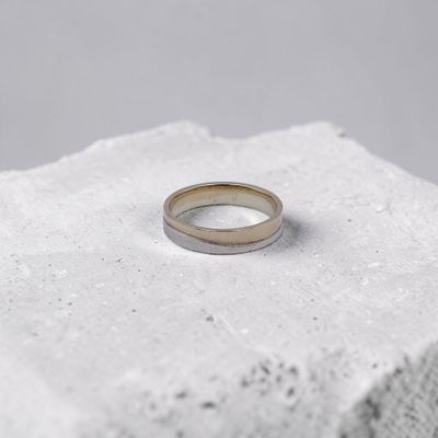 un gros plan d'une bague posée sur un parpaing