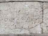 une plaque en pierre sur laquelle figure une carte, fixée au mur