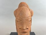 an image of a sculpture of a head on a black stand
