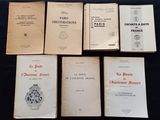 Six livres sont posés sur une table recouverte d'un tissu noir.