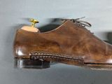 a pair of brown shoes hanging on a wall