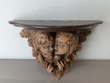 a wooden shelf that has two heads on it