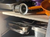 pots and pans sitting on a shelf in a kitchen