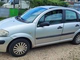 a small silver car parked on the side of the road