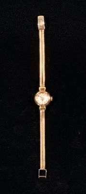 an image of a close up of a wrist watch on a black surface