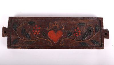 un gros plan d'une plaque en bois sur laquelle figure un cœur rouge