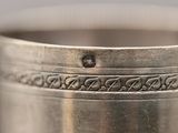 an antique silver plated cup with a decorative design on the rim