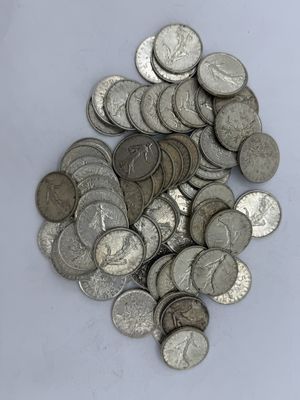 une pile de pièces d'argent posée sur une surface blanche