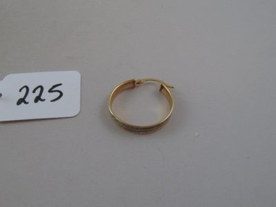 a small gold ring and a tag on a table