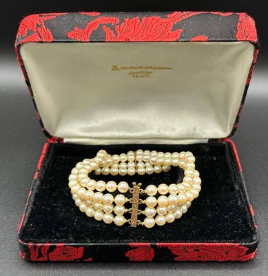 a close up of a necklace and bracelet in a box on a table