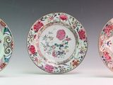 three plates with floral designs on them sitting next to each other