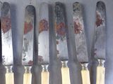 six knives are lined up next to each other on a table
