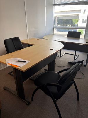 un bureau avec une chaise et un ordinateur portable posé dessus, dans une pièce