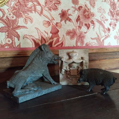 deux figurines d'animaux posées sur une table devant un papier peint