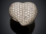 a diamond heart shaped ring on a black surface