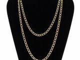 a gold chain necklace on a mannequin display