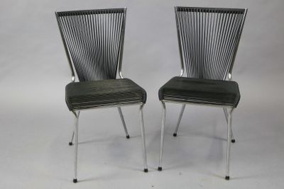 pair of black chairs with metal legs and a black seat