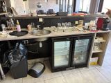 a kitchen with a sink, refrigerator, and other items on the counter