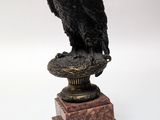 a statue of a bird on a pedestal on a white background
