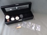 une boîte noire contenant une montre et une autre montre à l'intérieur